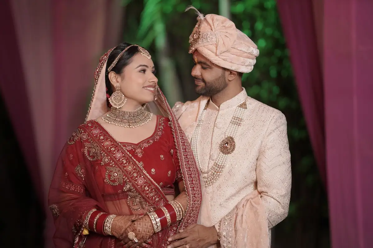 A bride in red and her groom at a formal family wedding
