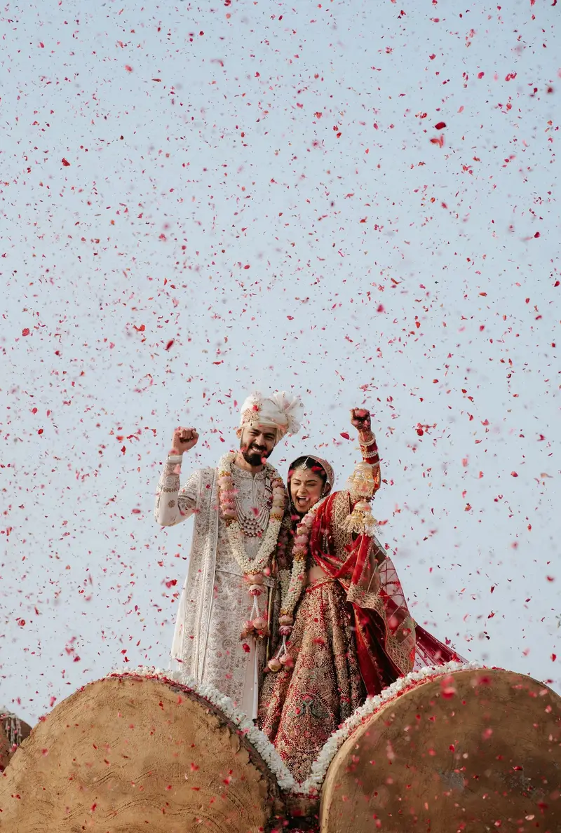 A bride and groom celebrating under a shower of rose petals